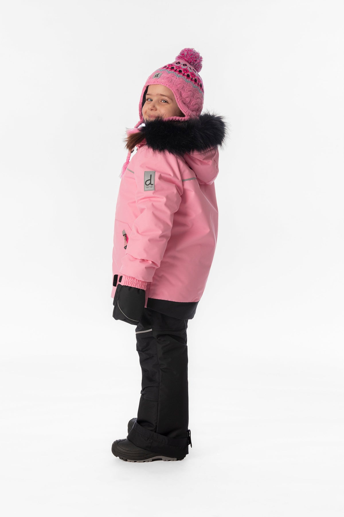 Girl in the pink and black Deux par Deux DISCOVER snowsuit, side view