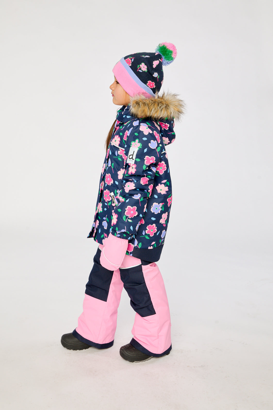 Child wearing the blue floral DISCOVER two-piece snowsuit by Deux par Deux, third lookbook photo