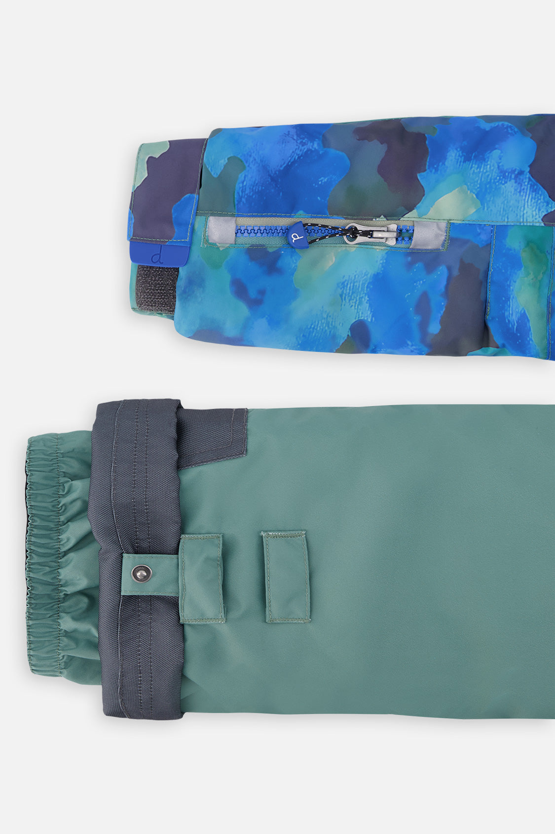 Close-up of the camouflage PLAY jacket ski-pass sleeve pocket and green pant hem