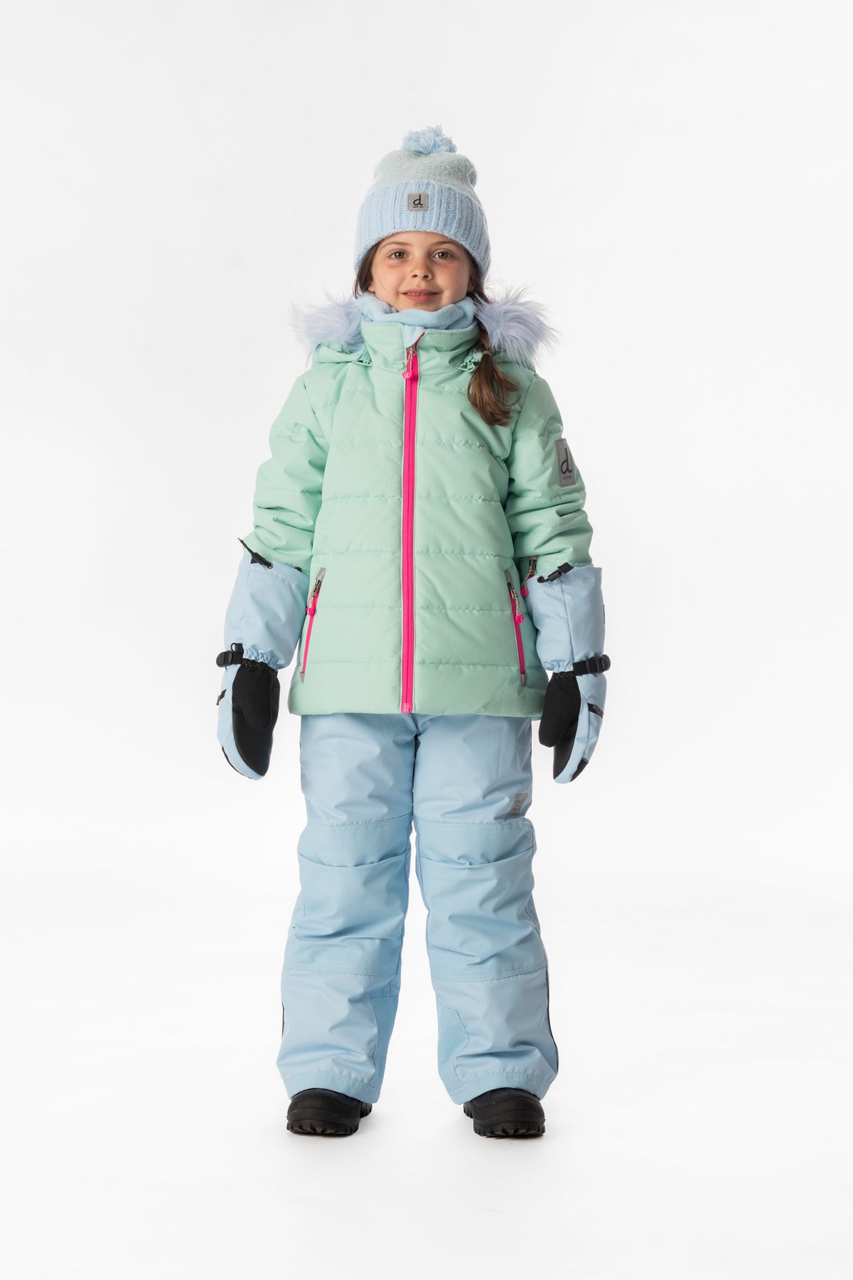 Girl standing in the mint green and light blue Deux par Deux PLAY snowsuit, full-length front view