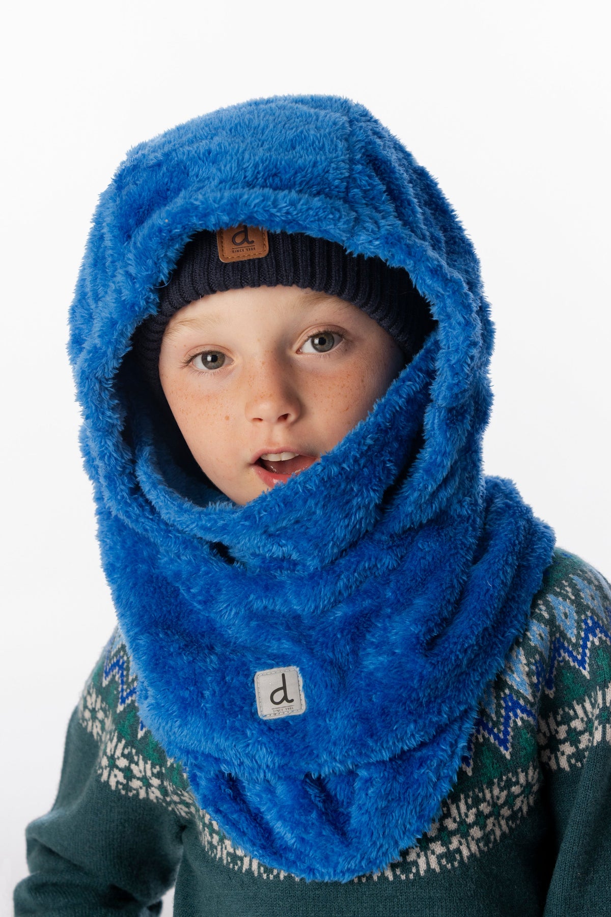 Child wearing the Deux par Deux blue plush fleece balaclava with the hood up over a knit beanie