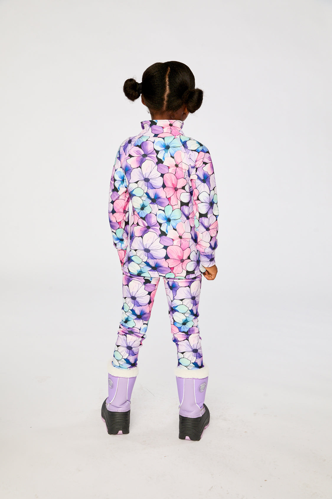 Child wearing the purple floral thermal top and pants, back view