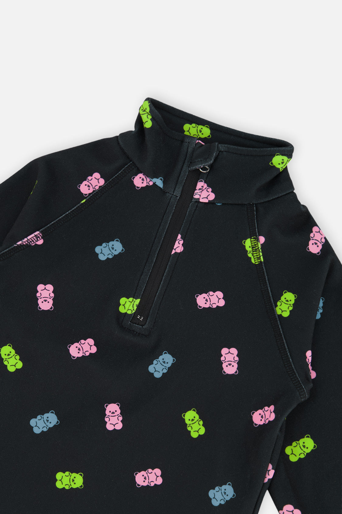 Close-up of the half-zip collar and pink, blue and green gummy bear print on the black thermal underwear top