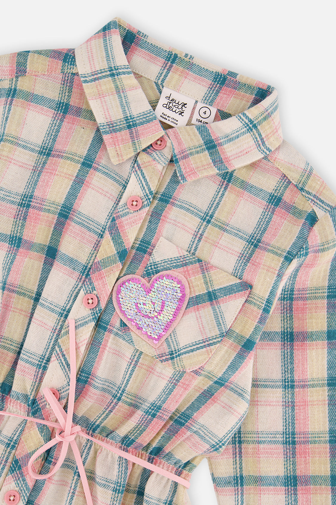 Close-up of the plaid collar, buttons and sequin heart pocket on the shirt dress