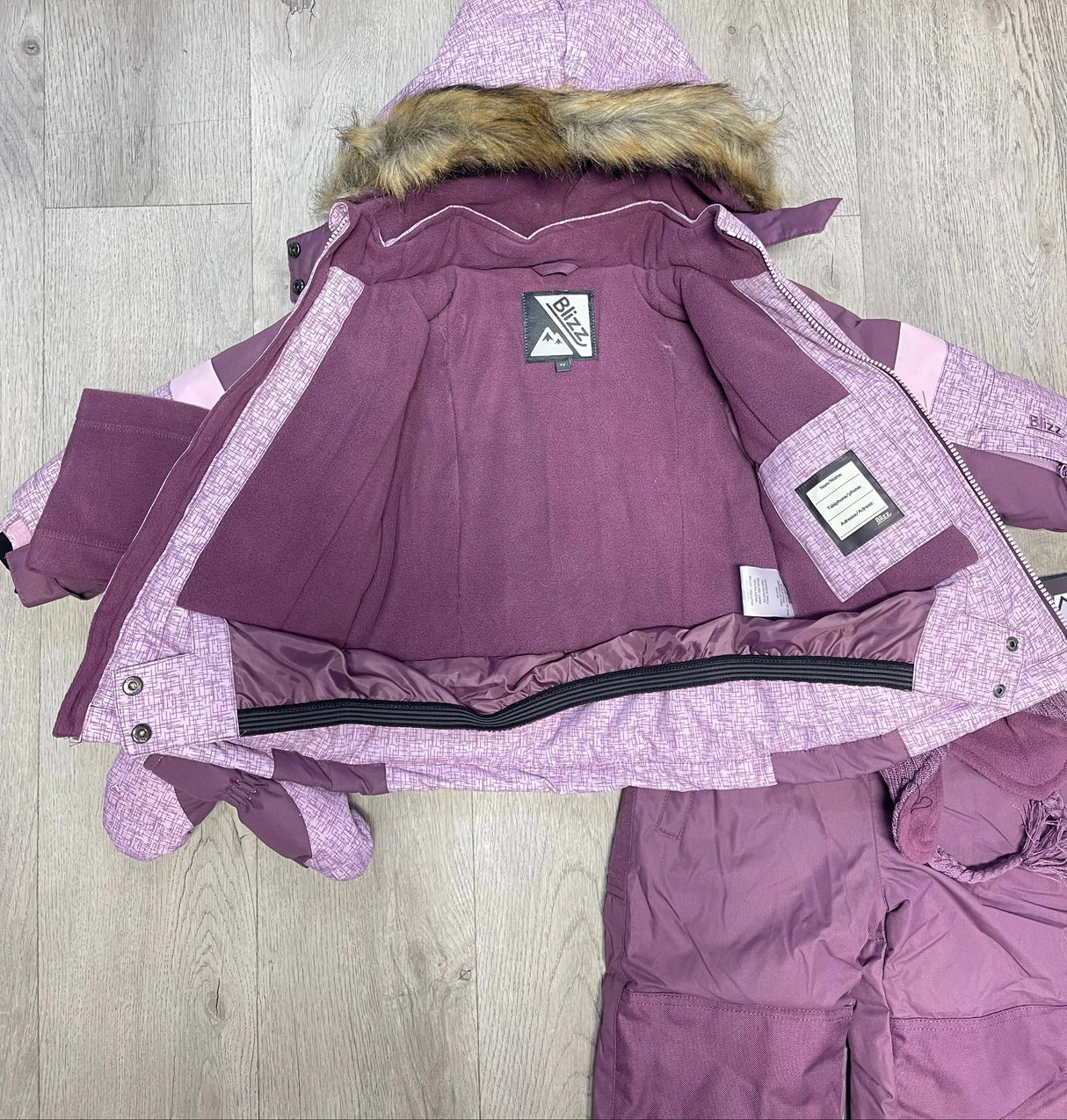 Open view of Blizz girls Lavender snowsuit jacket showing inner lining, snow skirt, and winter construction.