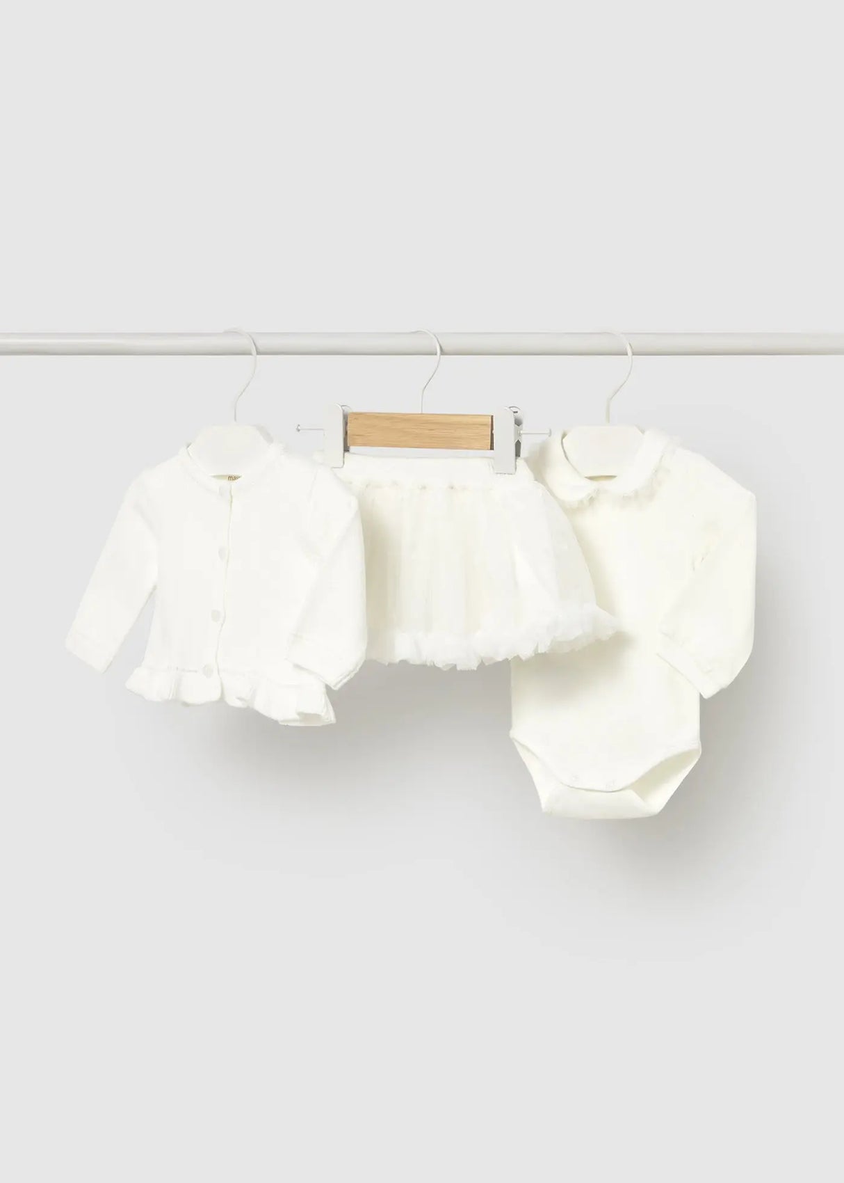 Ivory baby girl outfit set with cardigan, bodysuit, and skirt on hanger
