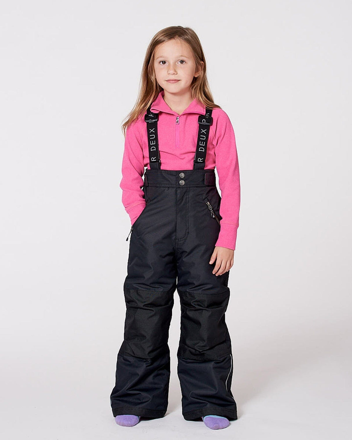 Model wearing black snow bibs, adjustable suspenders, breathable shell.