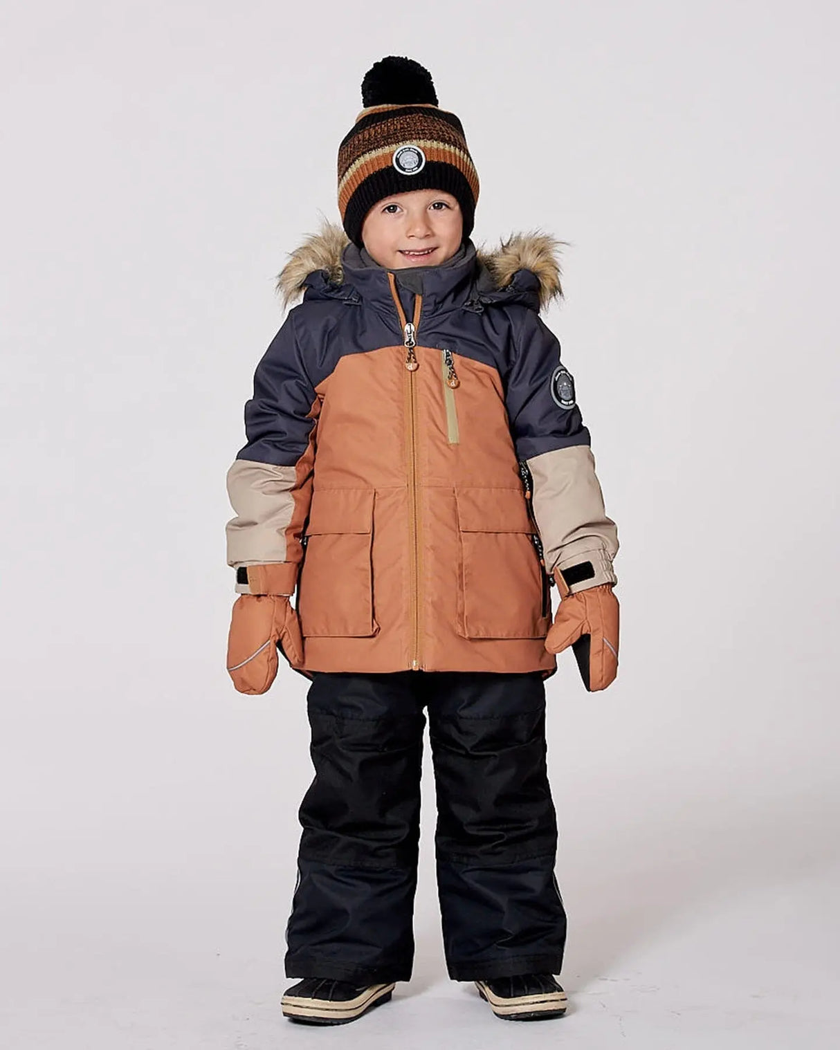 Model in colorblock jacket and snow pants, detachable hood and snow skirt.