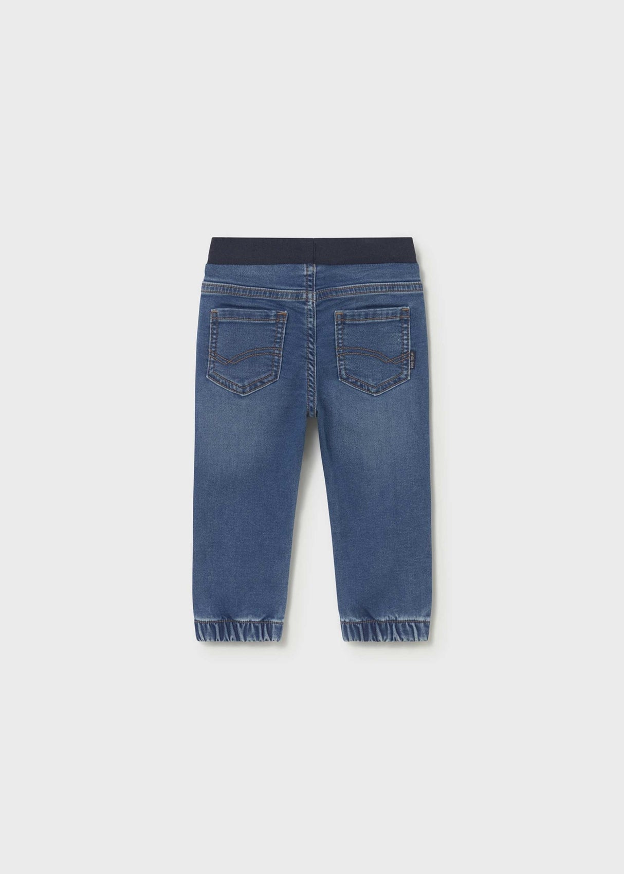 Back view of Mayoral baby boy jogger jeans showing Dark Blue denim wash and cuffed leg openings.