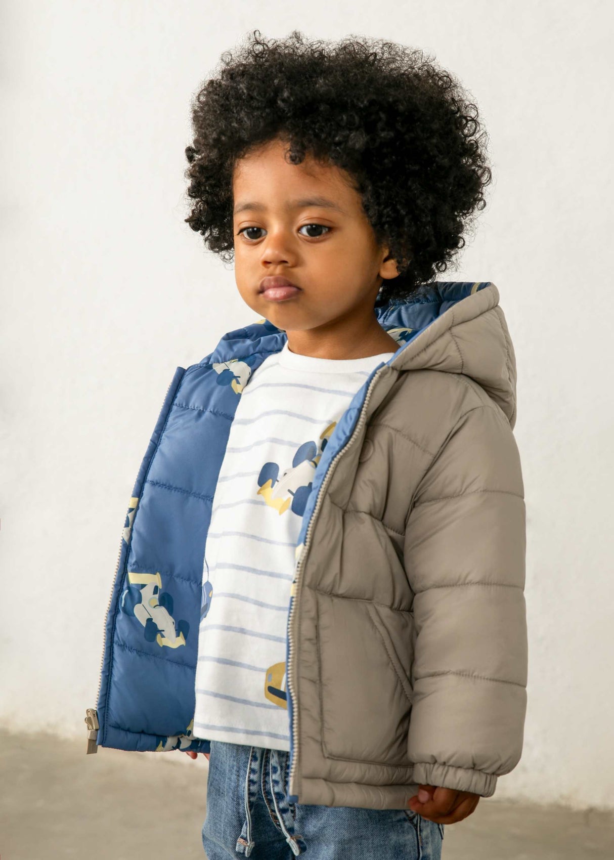 Baby boy wearing Mayoral reversible puffer jacket on the printed Blue side for cold-weather outings.