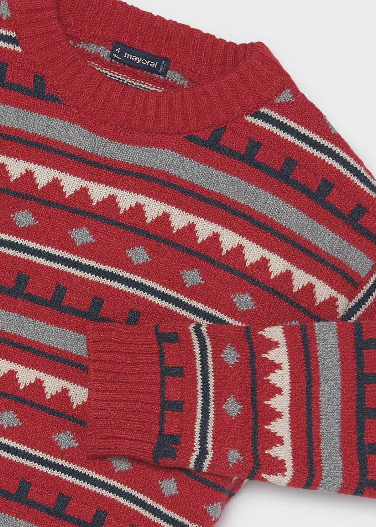 Close-up of the ribbed collar, cuff and jacquard pattern on the red sweater