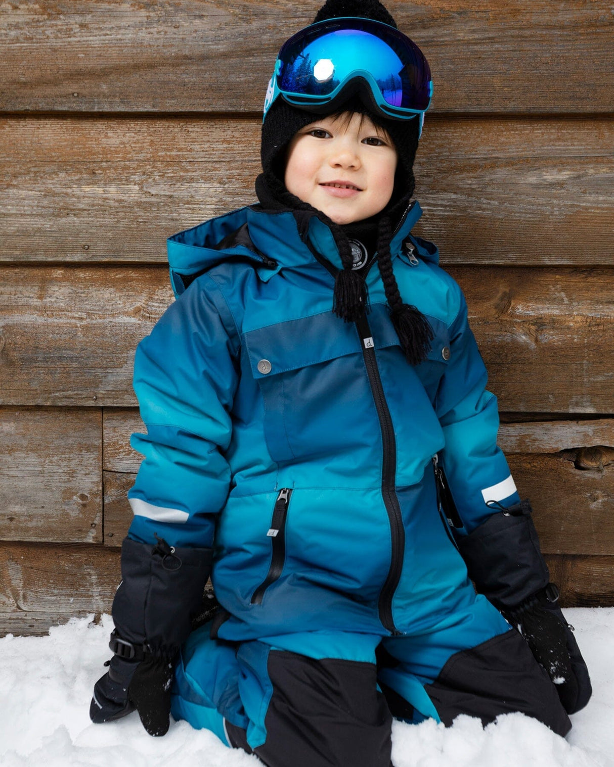 Child wearing Deux par Deux teal gradient insulated snowsuit outdoors 1