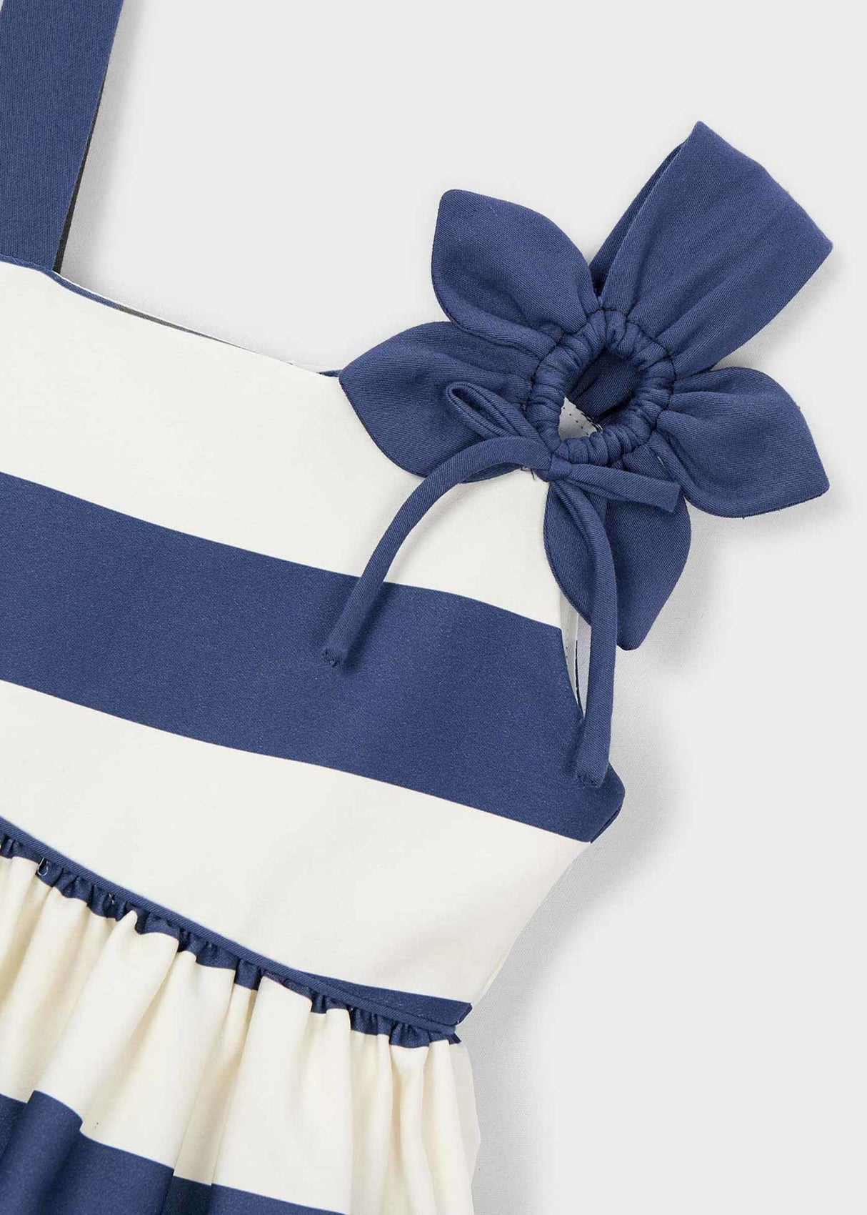Closeup of Mayoral girls dress showing Navy flower applique, stripe detail, and cotton fabric.