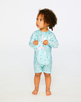 Studio front view of toddler girl wearing blue seahorse one-piece rashguard suit
