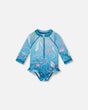 Front flat lay of Deux par Deux baby girl long sleeve rashguard one-piece in blue shell print