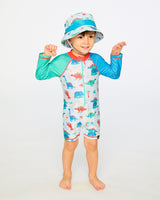 Toddler boy standing in grey dinosaur rashguard suit showing side view and sleeve length