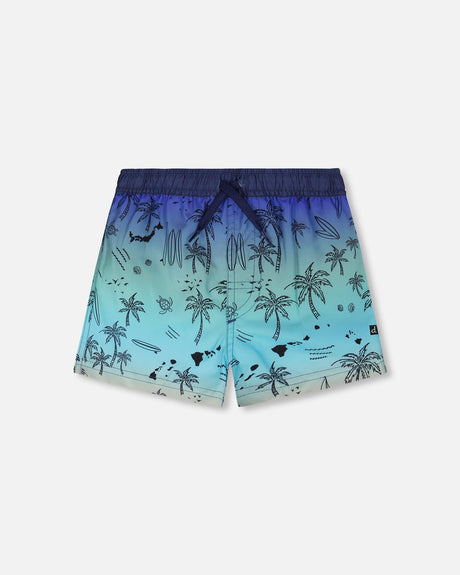 Front flat lay of Deux par Deux boy blue beach boys swim trunks with palm-tree print