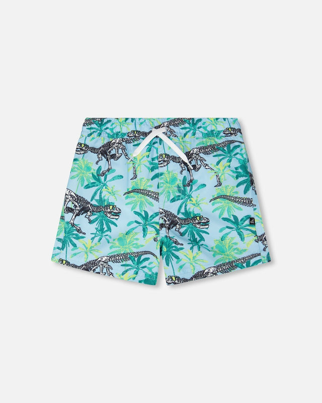 Front flat lay of Deux par Deux boy boardshorts in blue dinosaur skeleton and palm print