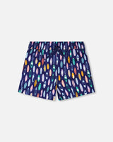 Front flat lay of Deux par Deux boy boardshorts in blue surfboard print