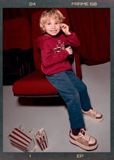 Boy wearing indigo straight-leg pants — lifestyle seated/play pose
