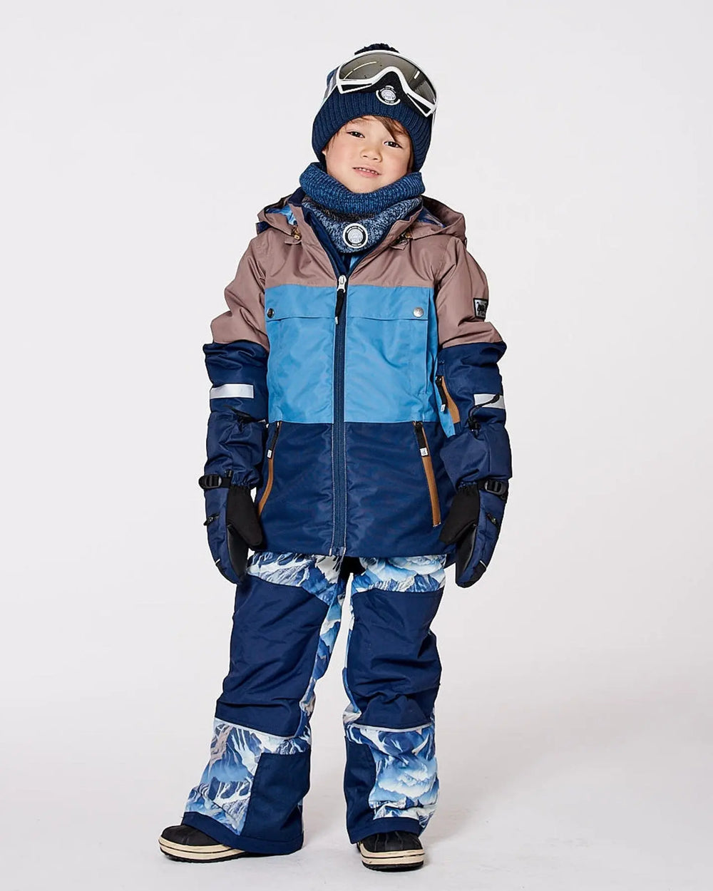 Child in Teknik snowsuit showing adjustable hems and snow guards