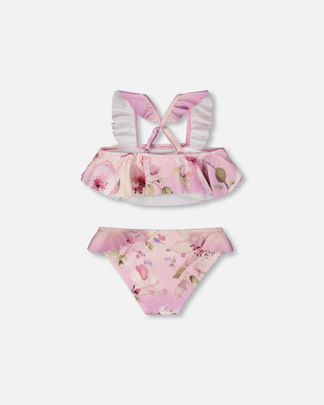 Back of the purple flower swim set laid flat, with the crossed ruffled straps over the flared top