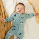Infant wearing tidal wave green dinosaur print footed sleeper with two-way zipper