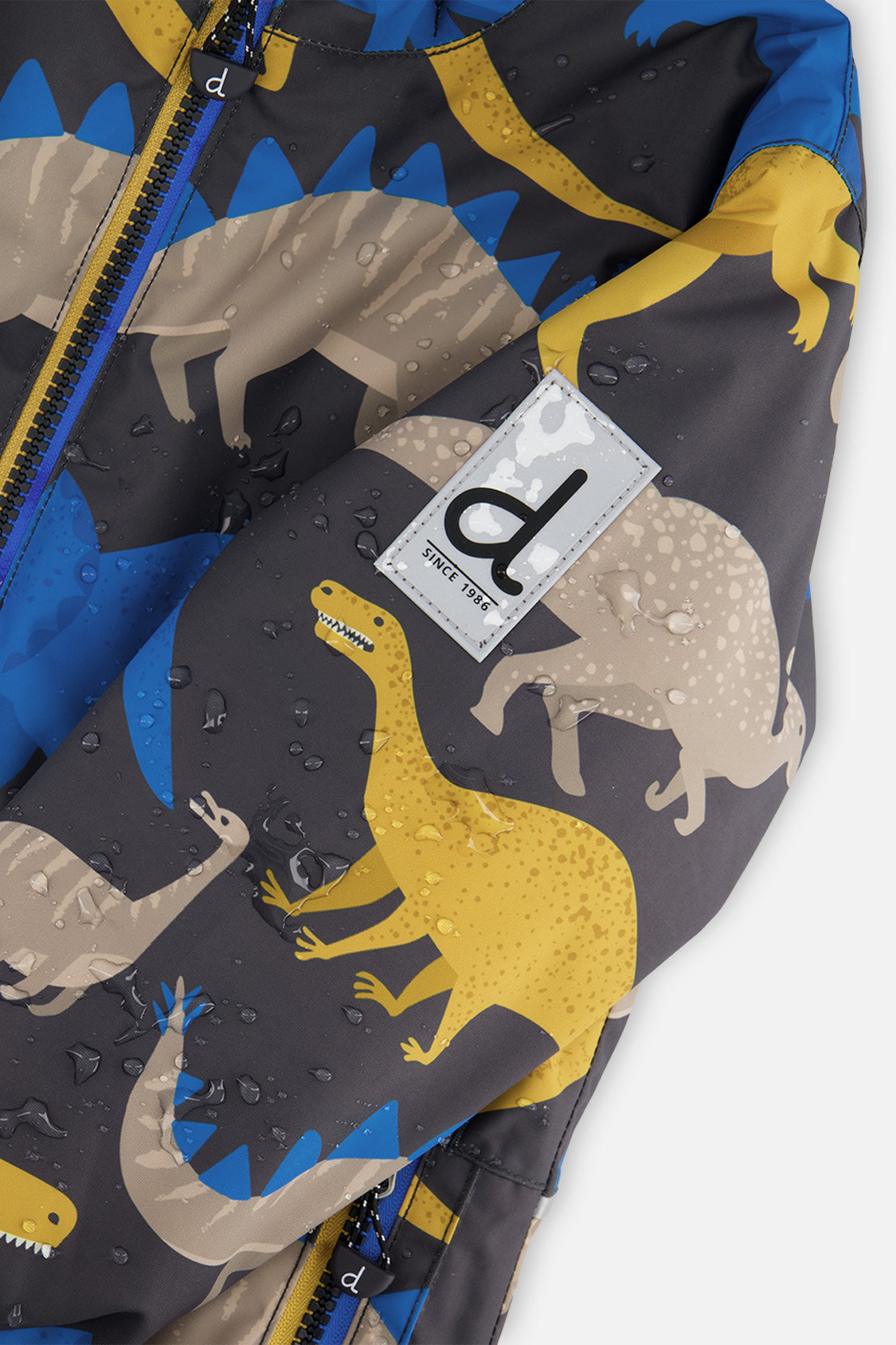 Close-up of the dinosaur-print CHILL jacket sleeve logo patch with water beading