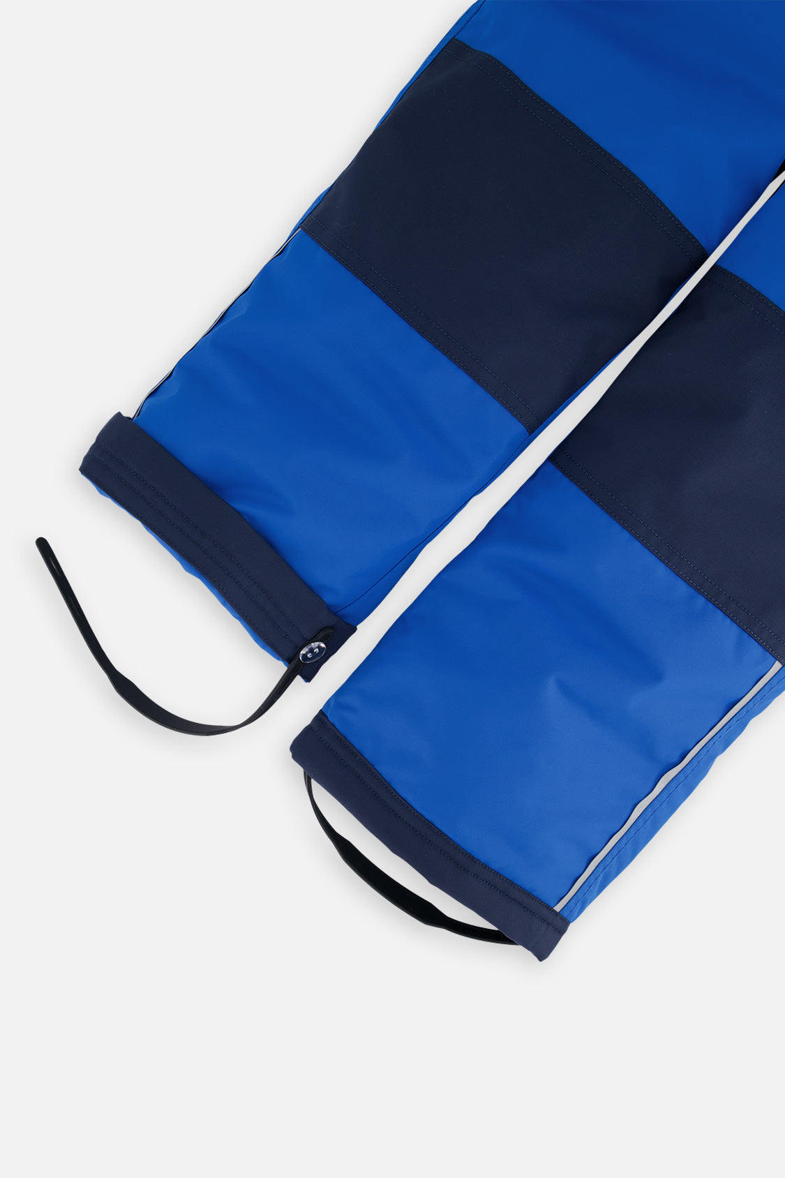 Close-up of the royal blue CHILL snow pant leg with adjustable foot strap