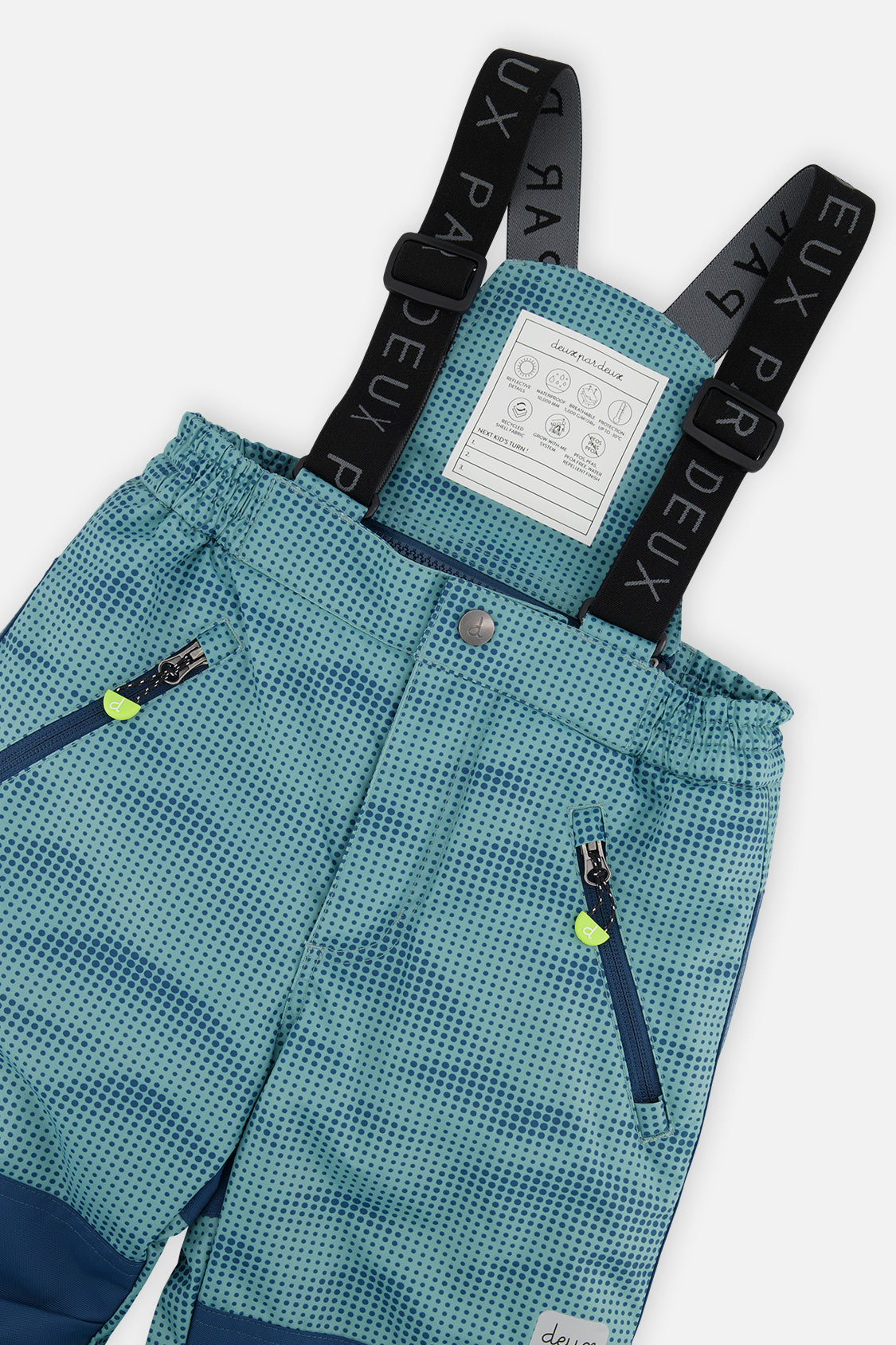Close-up of the Deux par Deux greyish blue PLAY snow pants suspenders and zippered pockets