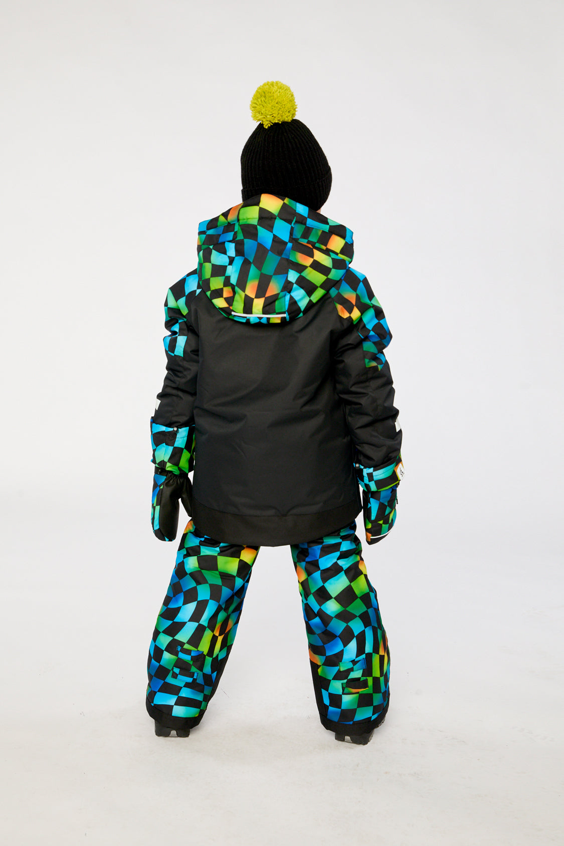 Child wearing the Deux par Deux black colorblock PLAY snowsuit with checkerboard pants, lookbook photo 3