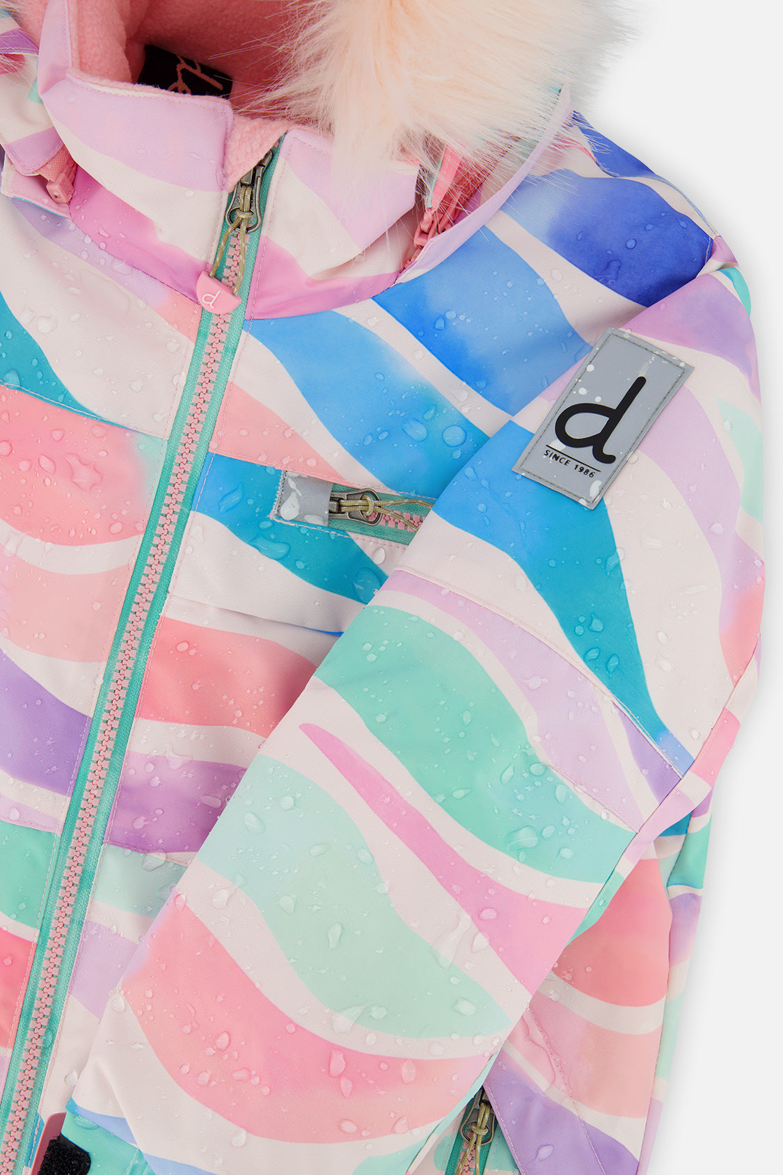Deux par Deux girls PLAY snowsuit, multicolor line print – close-up of the water-repellent jacket shell and logo patch