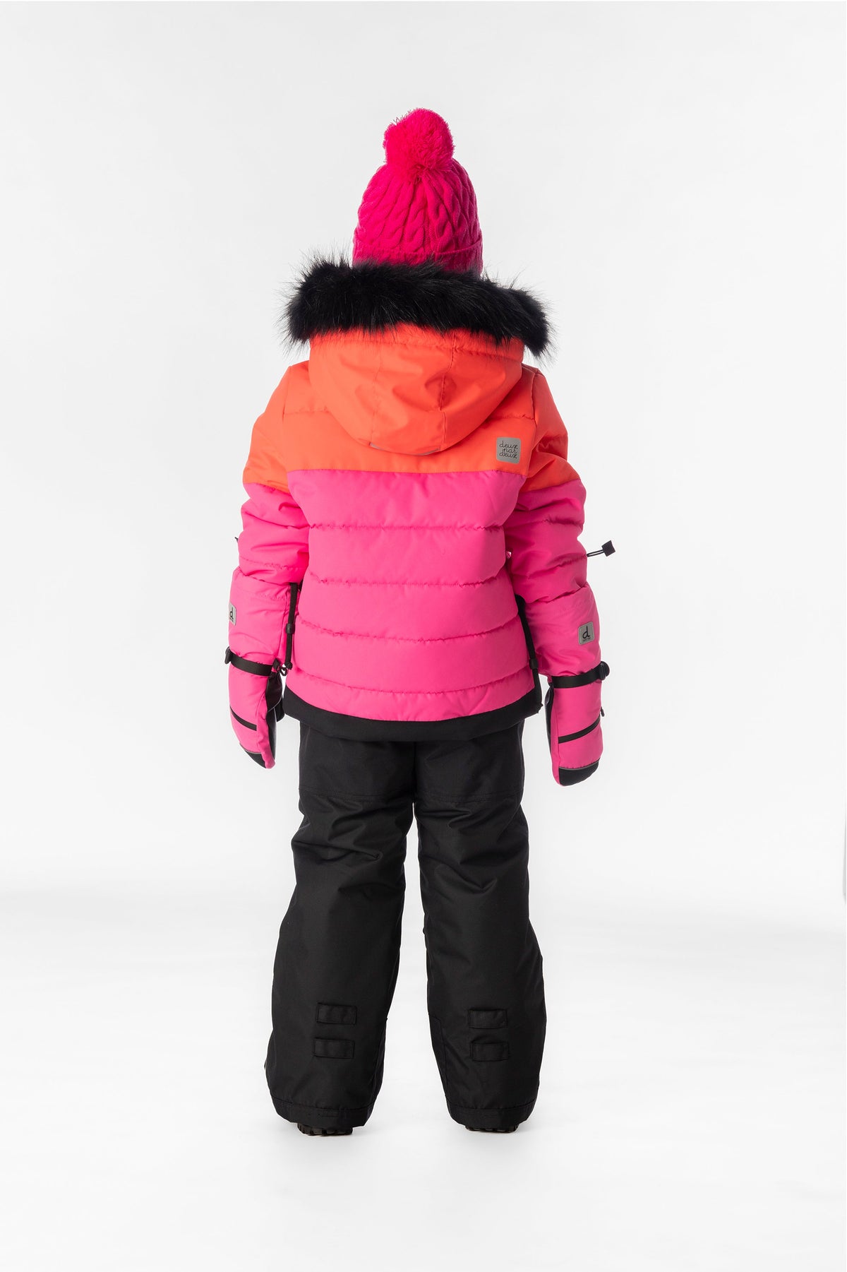 Girl in the coral, bright pink and black Deux par Deux PLAY snowsuit, back view
