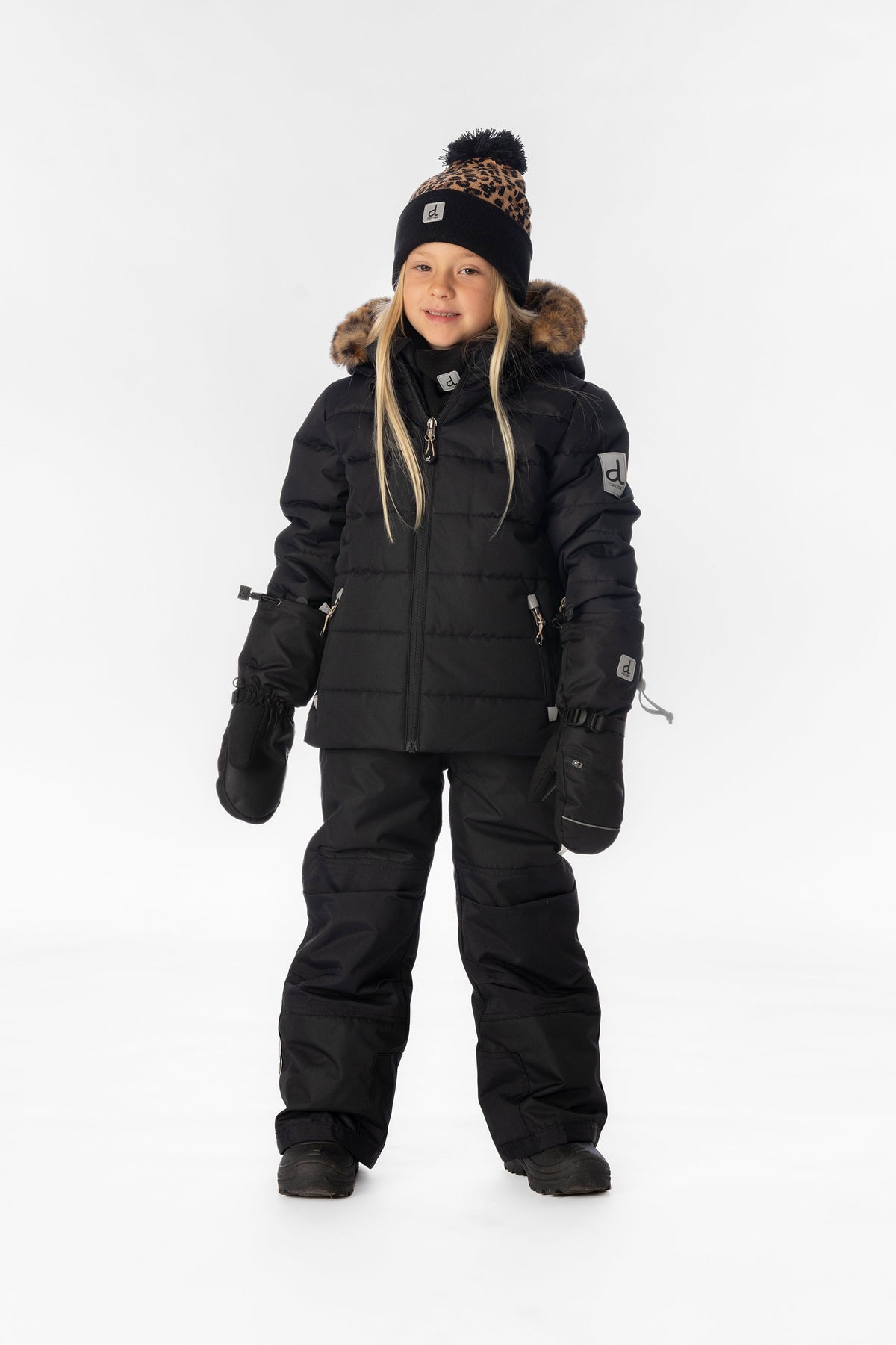 Girl standing in the black Deux par Deux PLAY snowsuit with leopard faux-fur trim, full-length front view