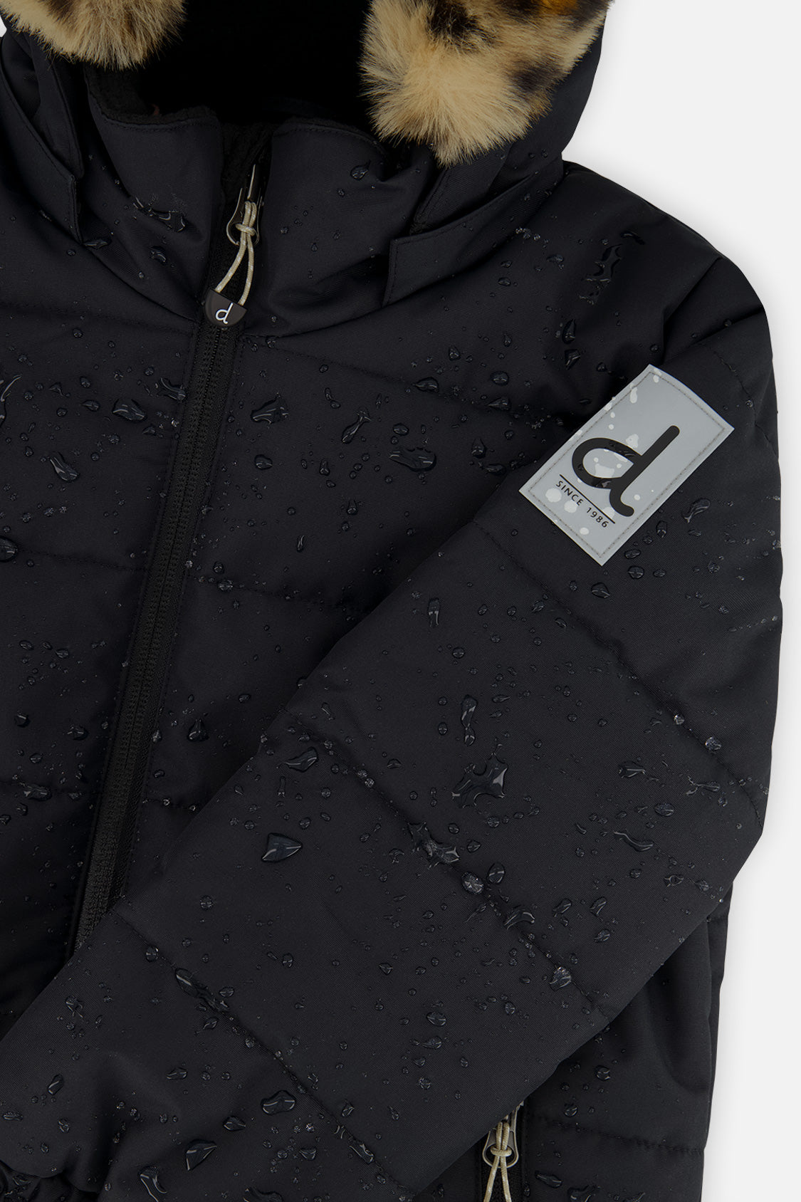 Deux par Deux girls PLAY snowsuit, black with leopard faux fur – close-up of the water-repellent jacket shell and logo patch