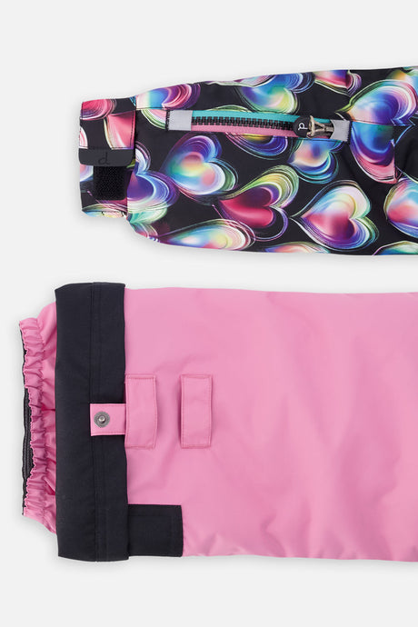 Close-up of the heart-print PLAY jacket sleeve ski-pass pocket and the adjustable pink pant hem