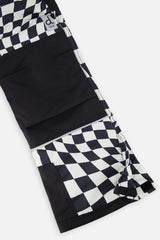 Close-up of the black reinforced knee and hem on the checkered snow pants
