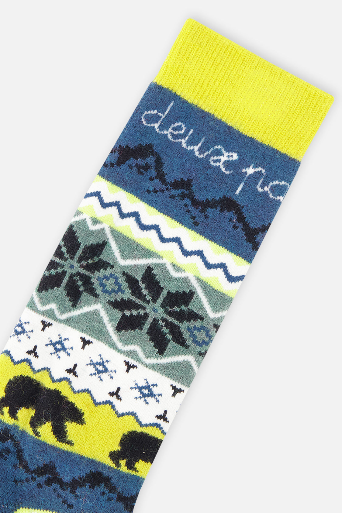 Close-up of the lime yellow cuff, script lettering and snowflake pattern on the navy ski sock