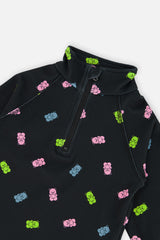 Close-up of the half-zip collar and pink, blue and green gummy bear print on the black thermal underwear top