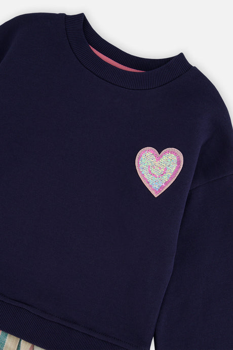 Close-up of the glittery heart patch and crew neckline on the Deux par Deux navy dress