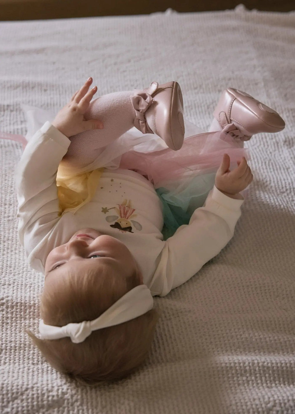 Overhead lifestyle shot of full 3-piece baby outfit with headband included for a gift-ready look.