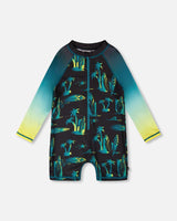Front flat lay of Deux par Deux baby boy long sleeve one-piece swimsuit in black surf print with gradient sleeves