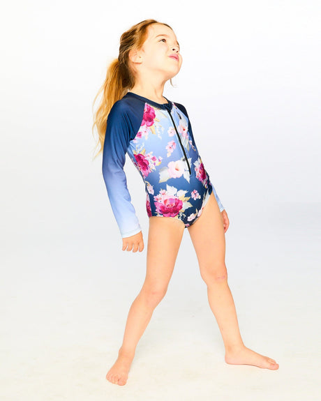 Girl standing in studio wearing Blue Rose rashguard swimsuit front view