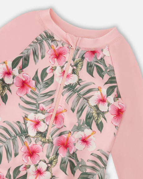 Close-up of hibiscus floral print and solid pink sleeves on girl rashguard swimsuit