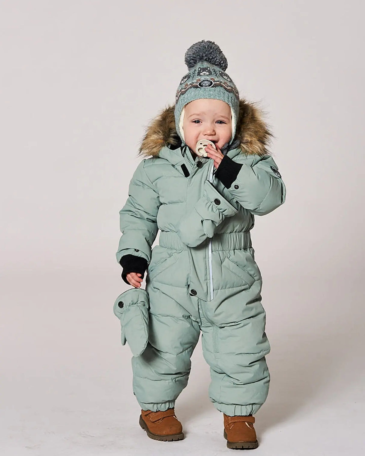 Baby wearing sage green puffy snowsuit front view