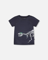 Front flat lay of Deux par Deux boy short sleeve kids rashguard in black with dinosaur skeleton print