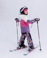 Side view of child skiing in Teknik snowsuit with helmet-friendly hood and waterproof zippers