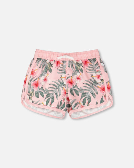 Front flat lay of Deux par Deux girl pink hibiscus girls swim shorts with curved hem