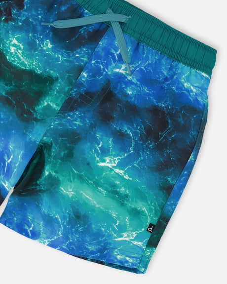 Close-up of waistband, mesh lining, and wave-effect print on blue swim shorts