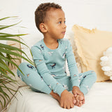 Toddler wearing tidal wave green dinosaur print organic cotton pajama set by Petit Lem